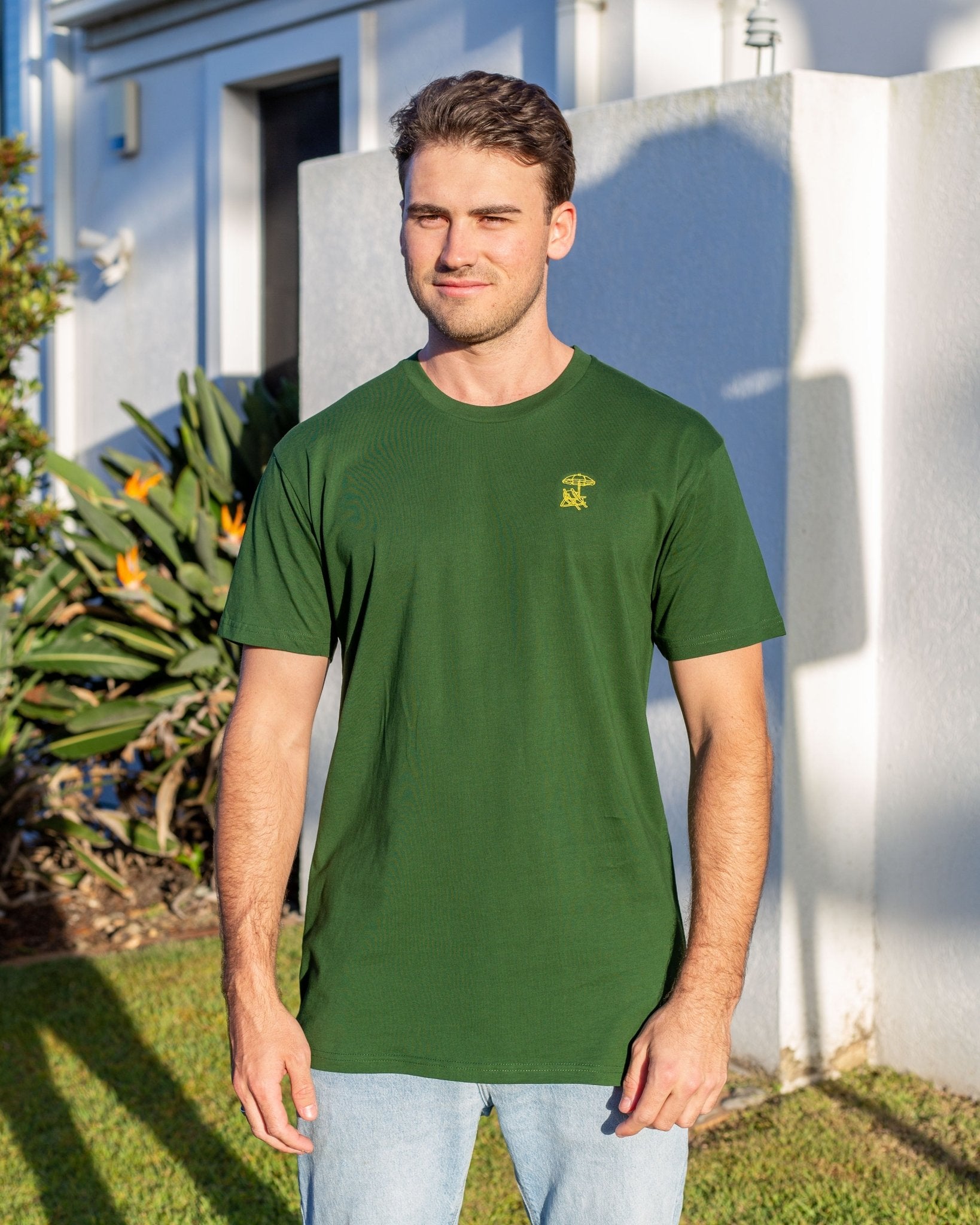 Man wearing green coloured tshirt with yellow embroidered design 