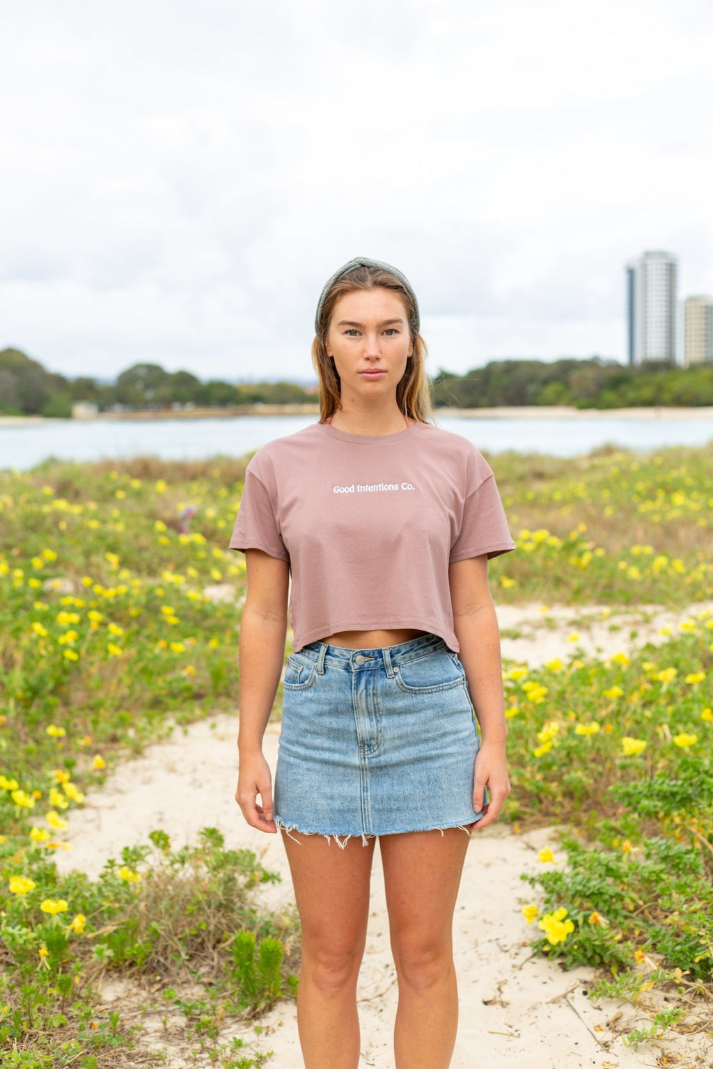 Woman wearing Hazy Pink crop top with a white embroidery design on it